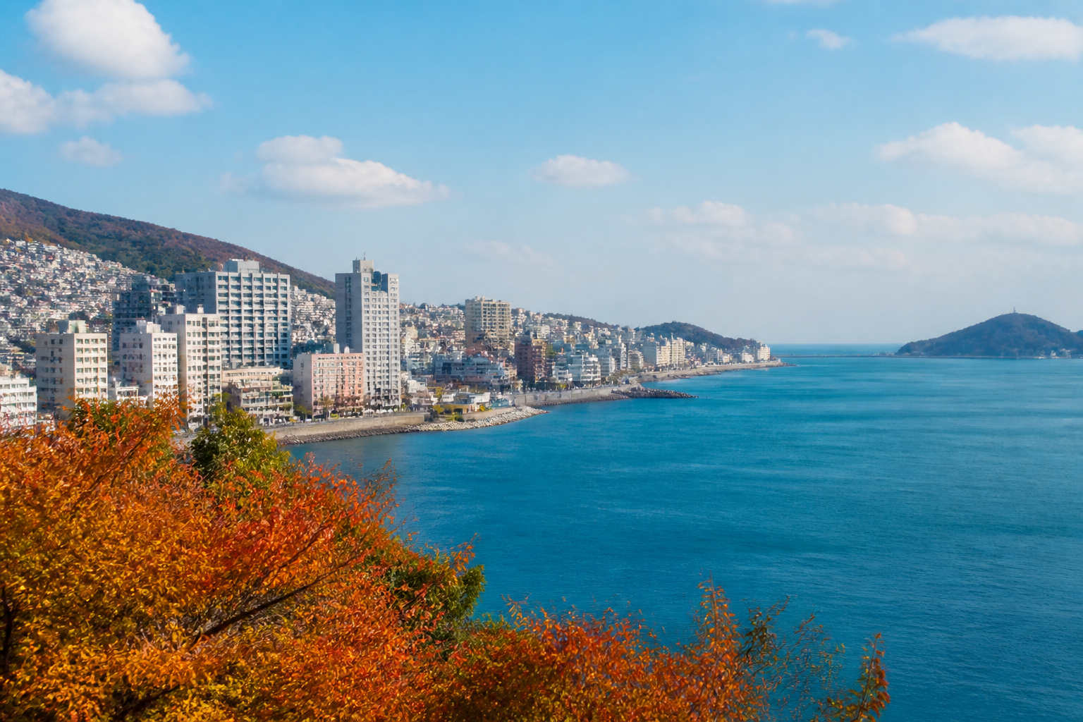 가을 맑은 날 부산 해안 도시 풍경과 언덕 위 건물들, 잔잔한 바다와 추석 명절의 밝은 분위기